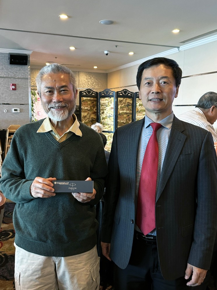 秦校长（右）向前任岭大校长郑国汉教授（左）致送纪念品。