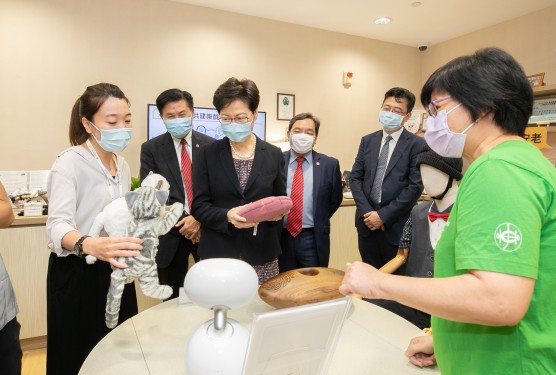 Chloe Siu Pui-yee, Project Manager of the Asia-Pacific Institute of Ageing Studies (left), demonstrates the application of gerontechnology in daily life to the Chief Executive at the Gerontech-X Lab.
