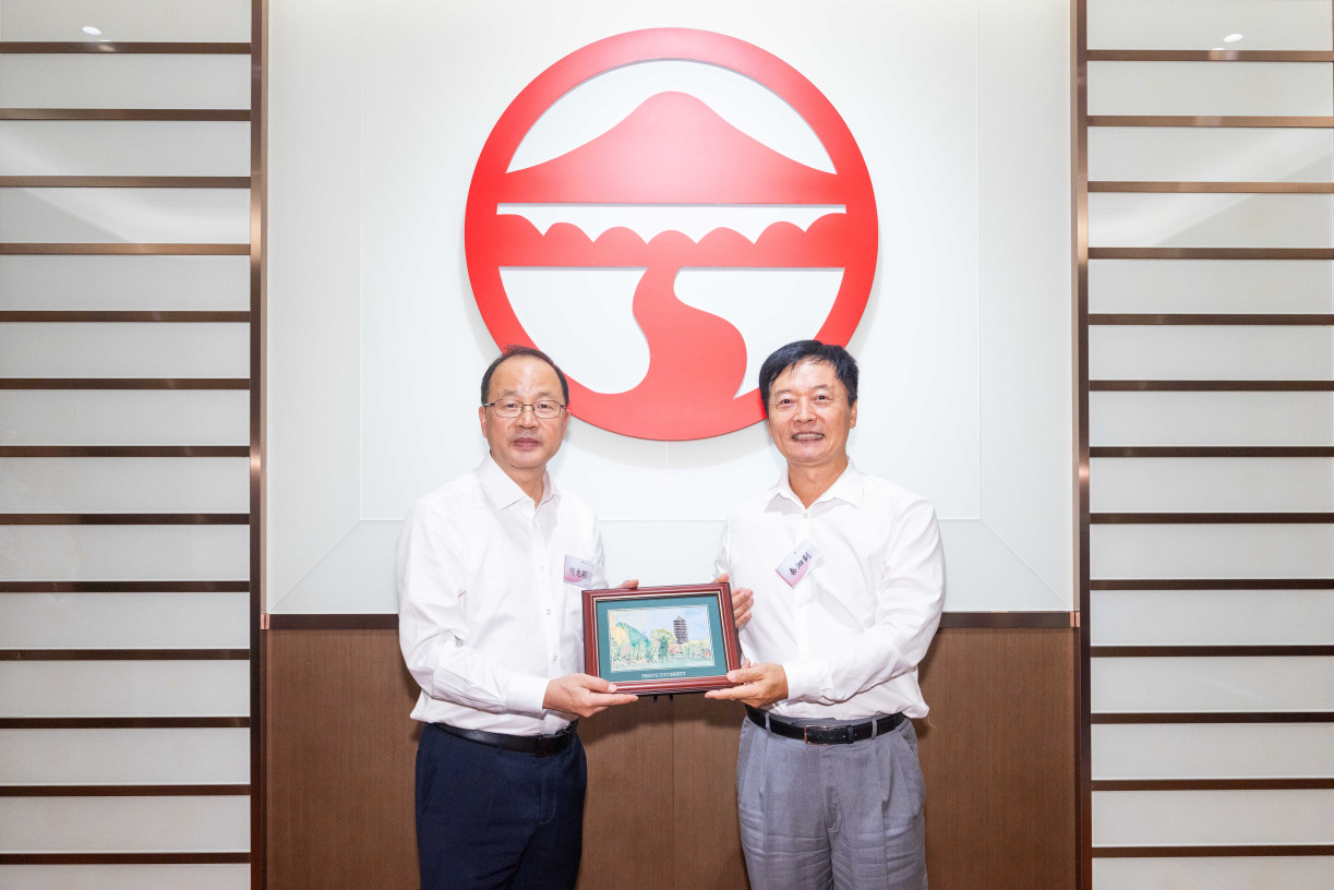 Mr He Guangcai, Secretary of the CPC Peking University Committee (left), presents a momento to Prof S. Joe Qin, President and Wai Kee Kau Chair Professor of Data Science at Lingnan University (right).