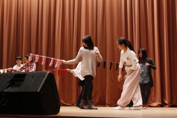 Lingnan students experience “riding a horse”, represented by waving a whip, on the stage.