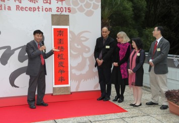 郑校长（左）向一众来宾介绍《岭下深耕弘博雅  南园播植庆羊年》新春对联。