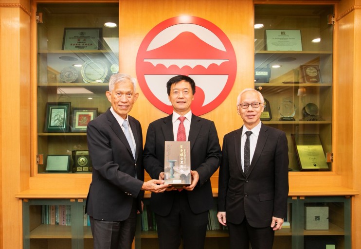 Mr Tin Hing Sin (left), Chairman of the Board of the Tin Ka Ping Foundation and Mr Tin Wing Sin (right), Members of the Board, present the souvenir to President S. Joe Qin (middle).