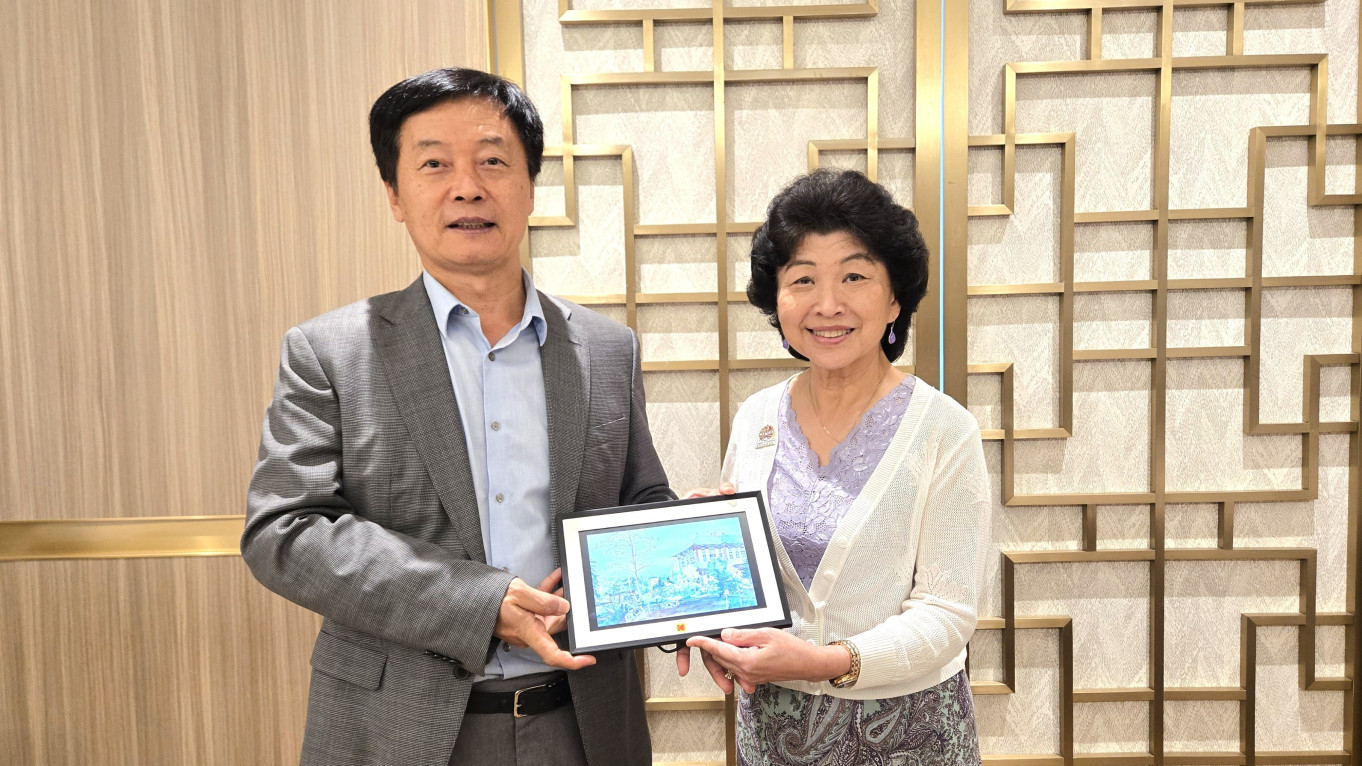 President Qin (left) presents a souvenir to Dr Currie (right).