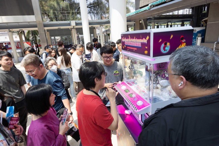 Participants playing the claw machine to collect souvenirs