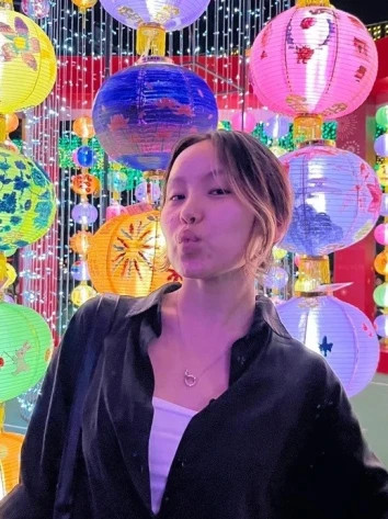 Kazakhstan female student smiling in Hong Kong among Chinese lanterns