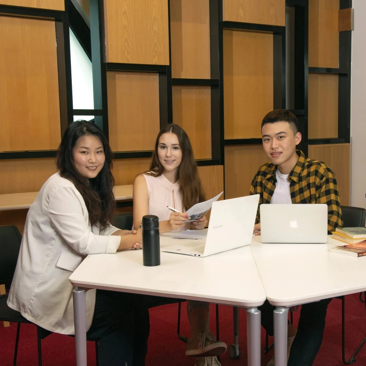 Group of international scholarship recipients at Lingnan University Hong Kong working on laptops