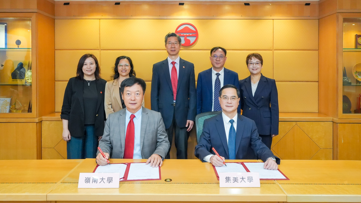 2026年4月23日岭南大学与集美大学合作备忘录签署仪式,两校代表于桌前准备签署,随行人员在后方合影