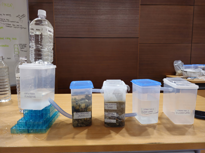  Multi-stage DIY water filtration system prototype built with plastic containers and tubing.