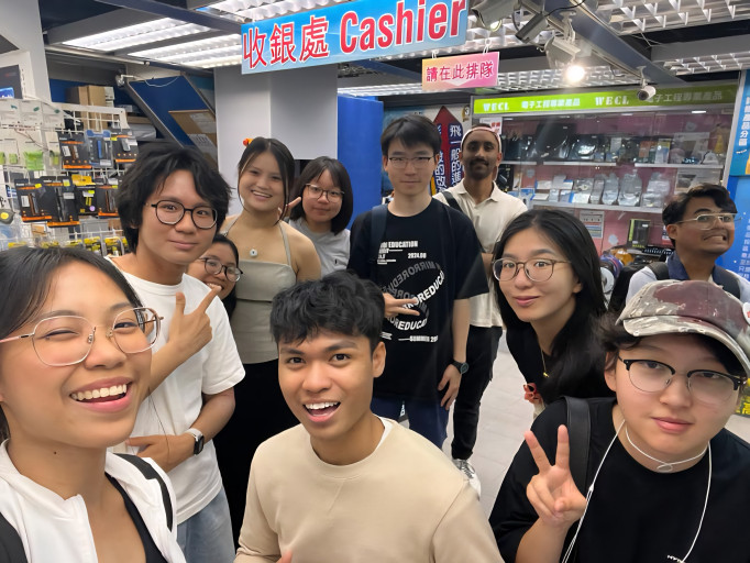  Group selfie of students visiting an electronics parts store.