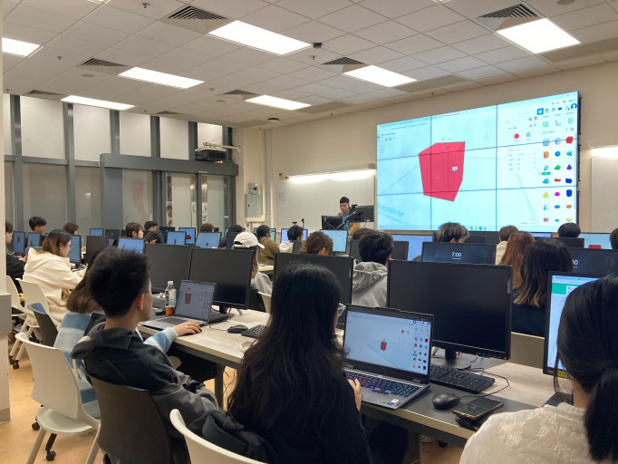 Students participating in a Tinkercad 3D modeling workshop in a computer lab.