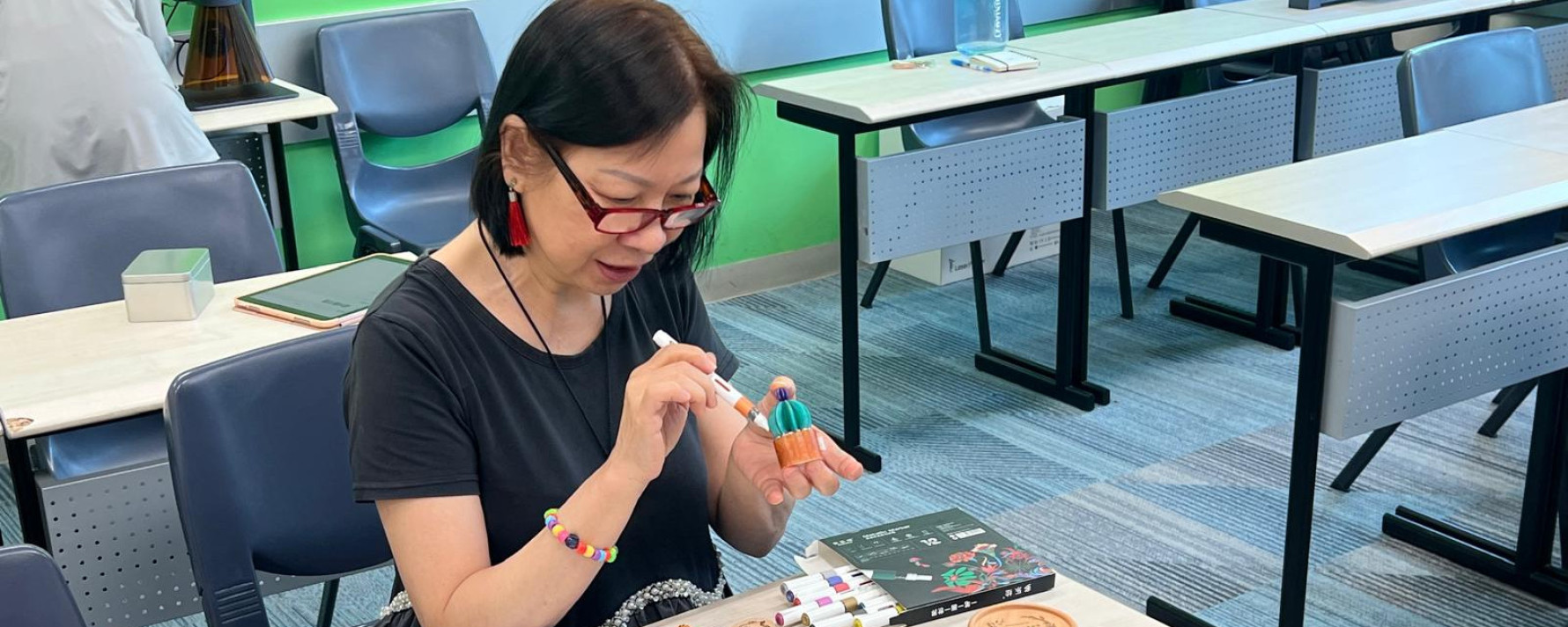 Participant painting a 3D-printed miniature model during a workshop.