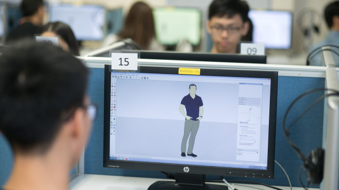 Student designing a 3D model on a computer in a computer lab.