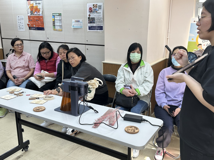 Community workshop demonstration on portable laser engraving with custom wooden samples.
