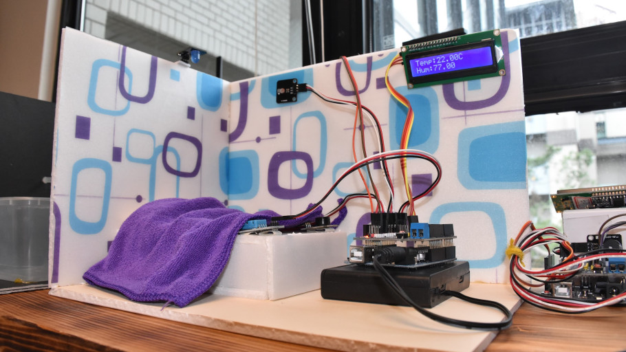  Arduino-powered miniature smart room prototype with temperature and humidity LCD screen.