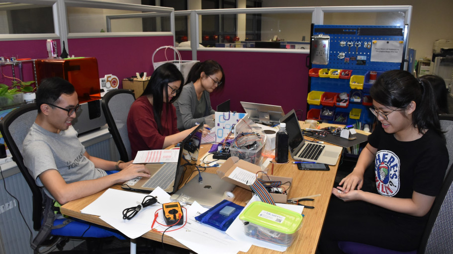  Students collaborating on electronics and software projects in a makerspace laboratory.