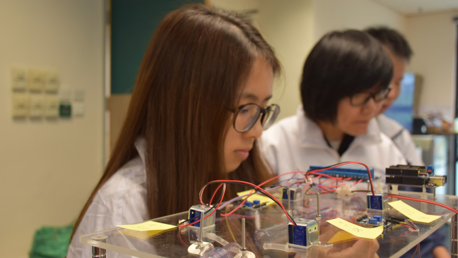  Students concentrating on fine-tuning an electronics prototype in a laboratory.