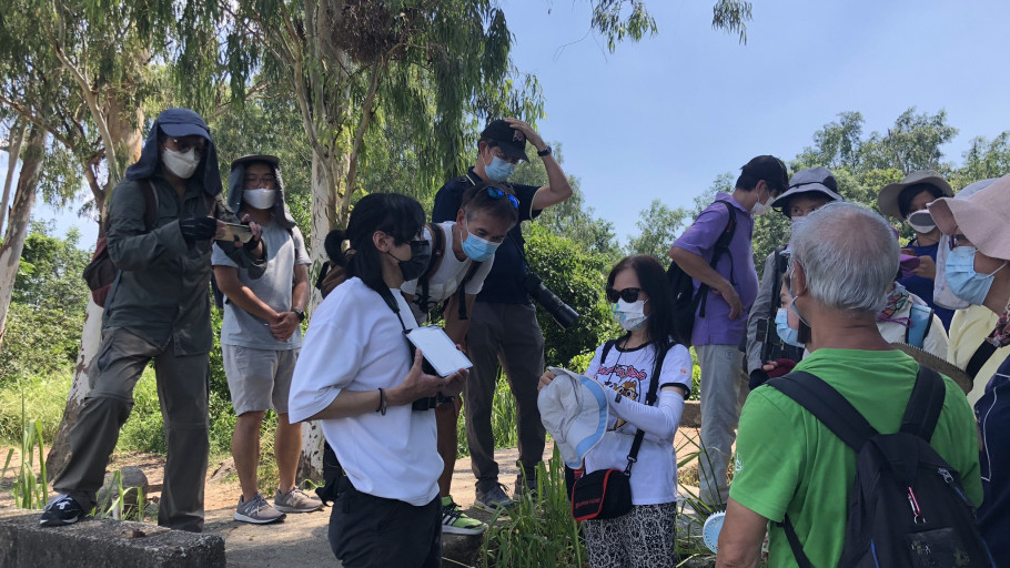  Instructor explaining a lesson on a tablet during an outdoor community field workshop.