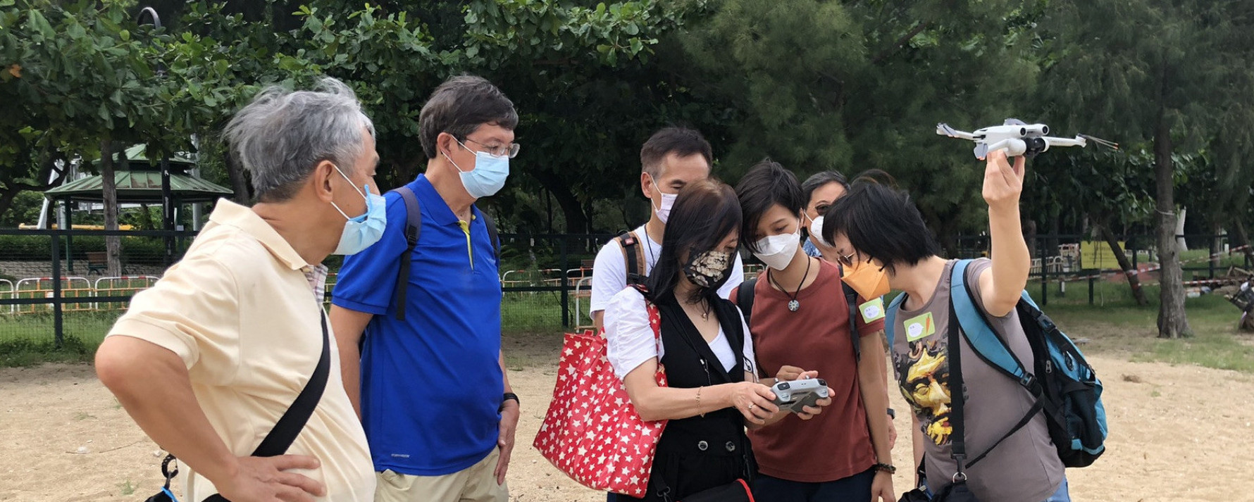 Outdoor community workshop participants observing a drone flight demonstration.