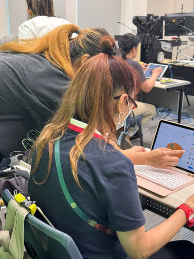 Project assistant guiding a workshop participant on 3D modelling.