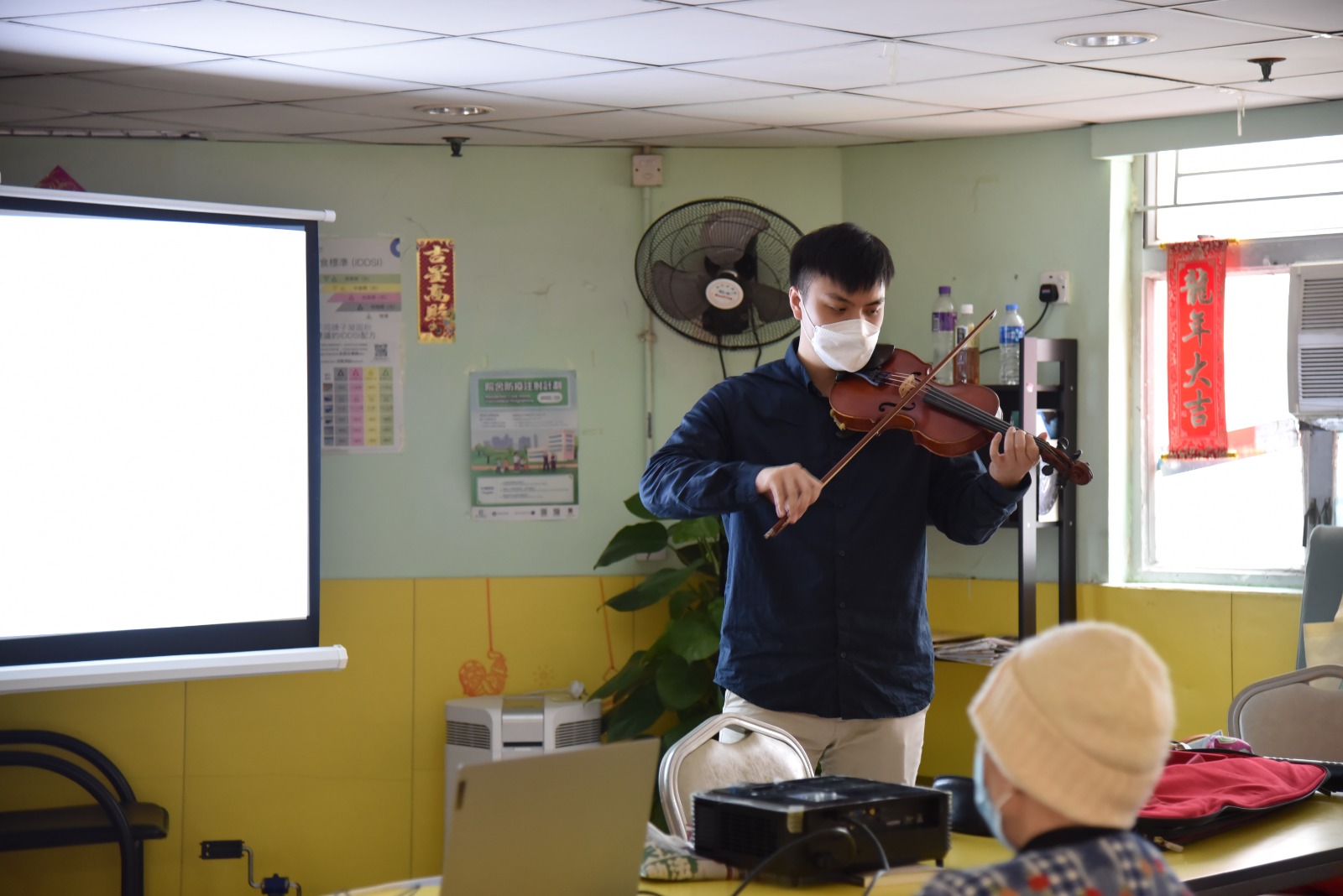 Staff playing the violin for the elderly