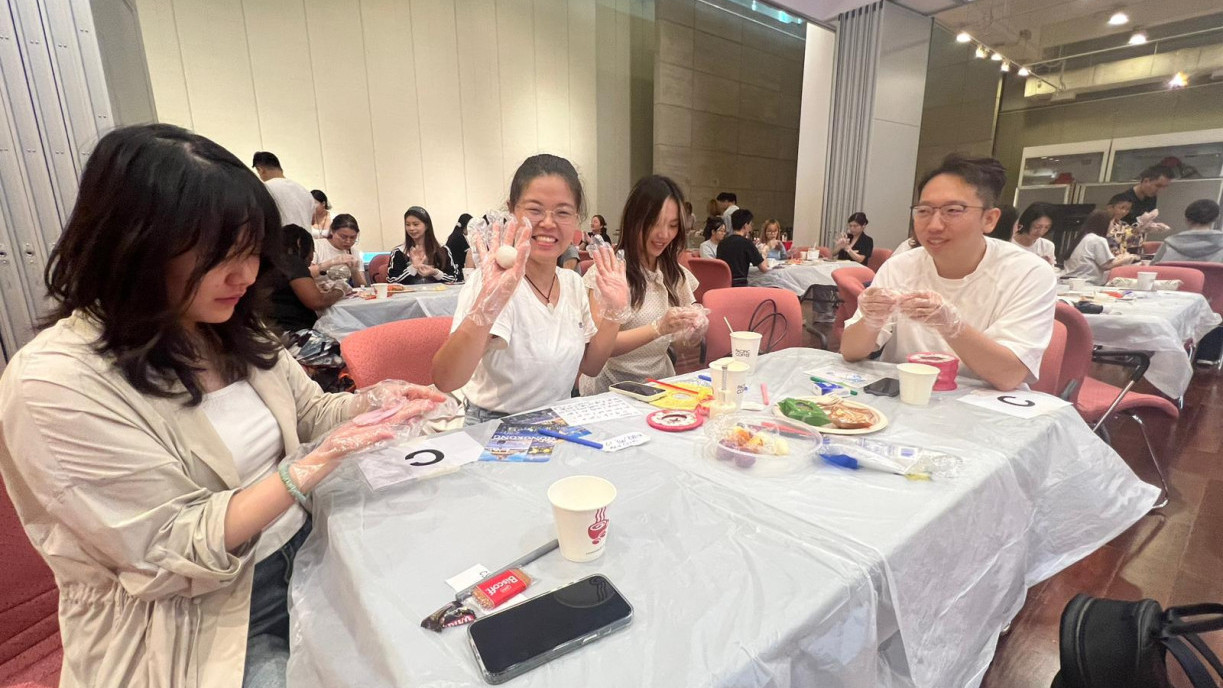 Postgraduates collaborated in small groups, enthusiastically mastering traditional mooncake-making techniques.