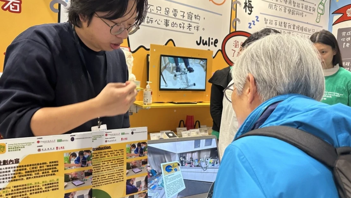 A Lingnan staff member explains the Gerontech project to a visitor.