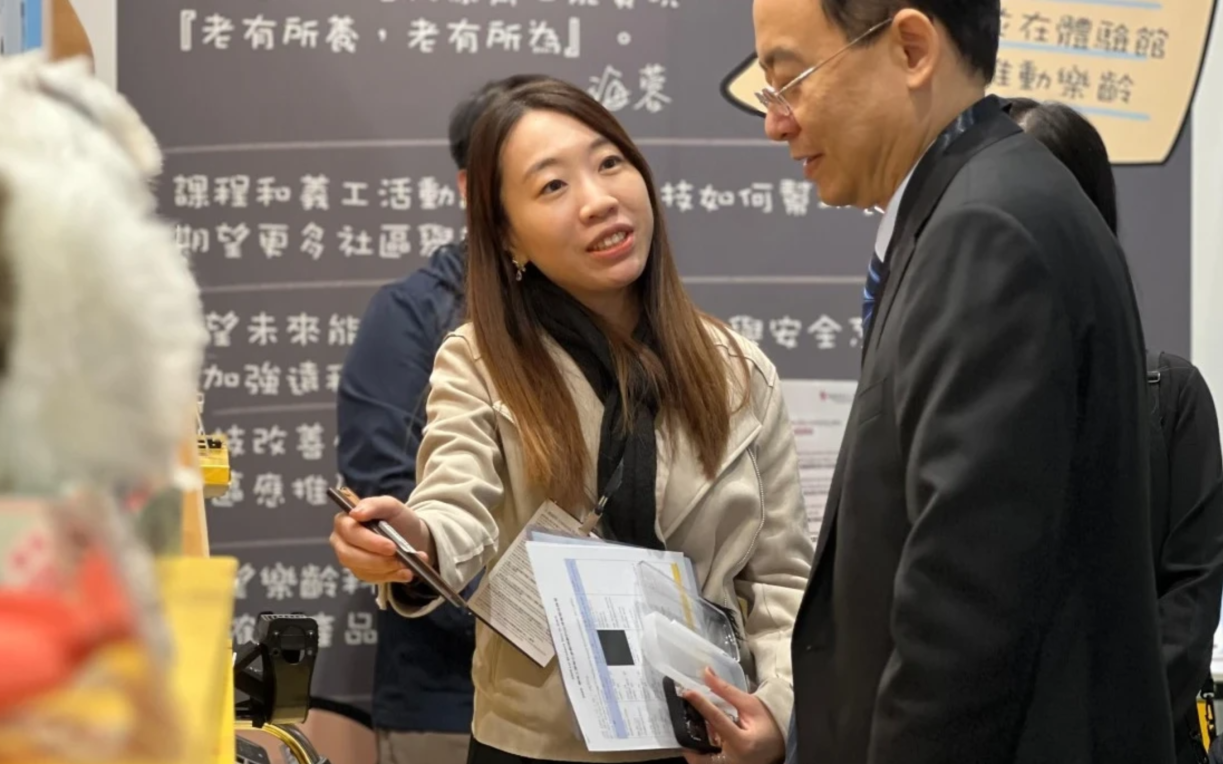 Dr Siu explains the exhibits to a visitor.